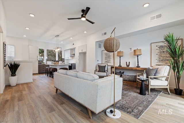 living area featuring light wood finished floors, a ceiling fan, visible vents, and recessed lighting