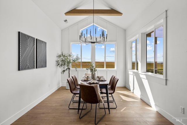 dining space featuring beamed ceiling, a chandelier, high vaulted ceiling, and light hardwood / wood-style flooring