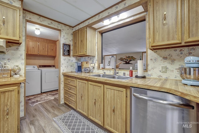 kitchen featuring dishwasher, sink, washing machine and dryer, crown molding, and light hardwood / wood-style floors