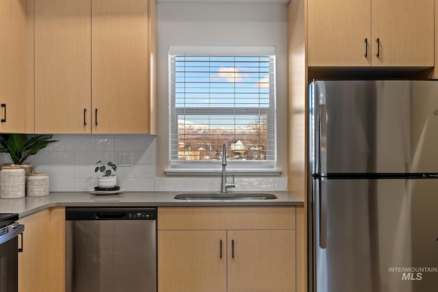 kitchen featuring backsplash, light brown cabinets, a sink, and stainless steel appliances