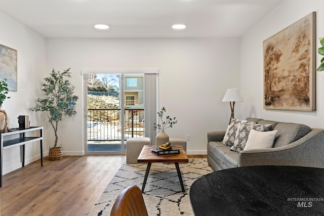 living area featuring recessed lighting, baseboards, and wood finished floors