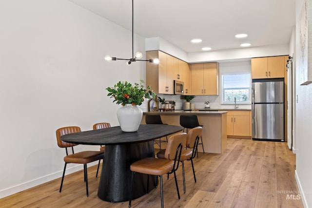 kitchen with a sink, light brown cabinets, and appliances with stainless steel finishes