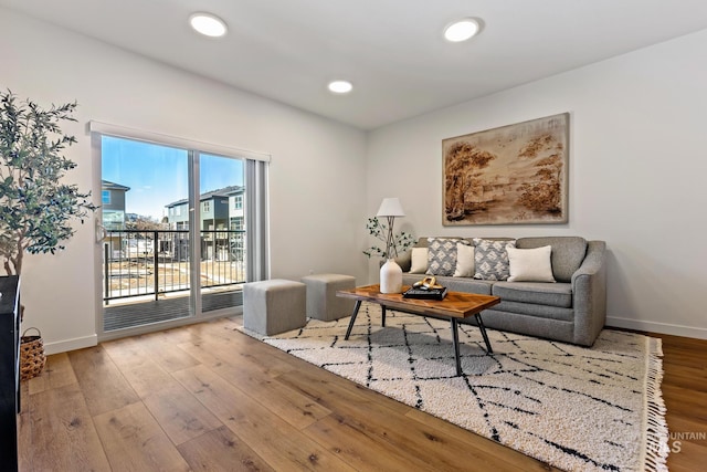 living area featuring baseboards, recessed lighting, and hardwood / wood-style flooring
