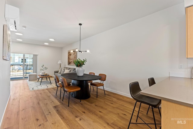 dining room with baseboards, light wood-type flooring, a notable chandelier, and recessed lighting