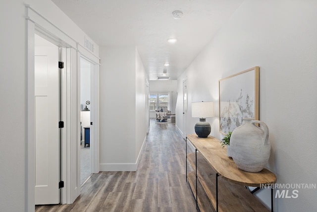 corridor with hardwood / wood-style flooring