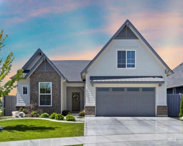 18245 N Arch Haven Way, Nampa, ID 83687 - view of front of home with brick siding, driveway, and a standing seam roof