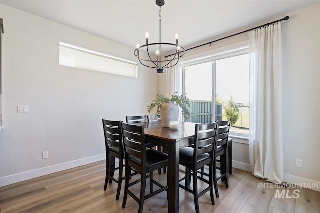 18245 N Arch Haven Way, Nampa, ID 83687 - dining space featuring a chandelier, baseboards, and wood finished floors