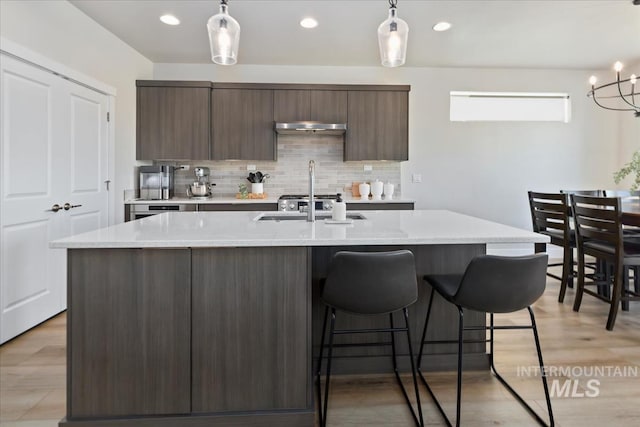 18245 N Arch Haven Way, Nampa, ID 83687 - kitchen with under cabinet range hood, modern cabinets, backsplash, a breakfast bar, and recessed lighting