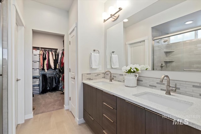 18245 N Arch Haven Way, Nampa, ID 83687 - bathroom with a stall shower, tasteful backsplash, double vanity, a spacious closet, and recessed lighting