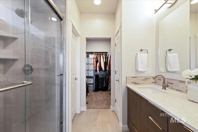 18245 N Arch Haven Way, Nampa, ID 83687 - bathroom with a stall shower, vanity, a spacious closet, and baseboards