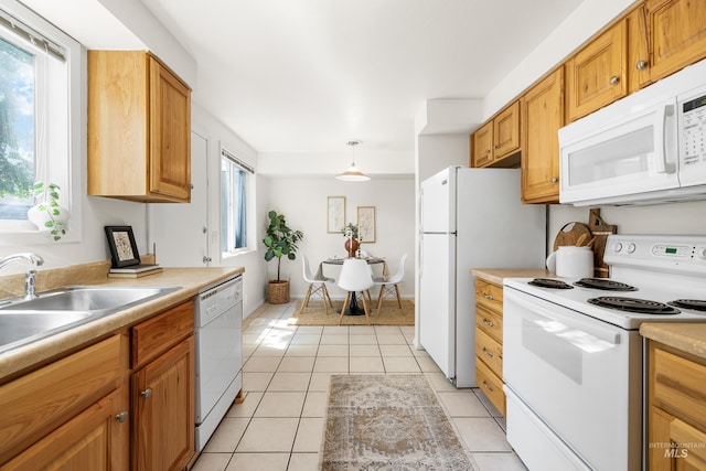 8305 W Rifleman St, Boise, ID 83704 - kitchen featuring white appliances, a sink, light countertops, light tile patterned floors, and brown cabinetry