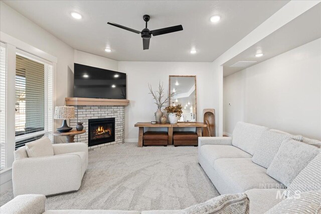 carpeted living area with ceiling fan, recessed lighting, a fireplace, visible vents, and baseboards