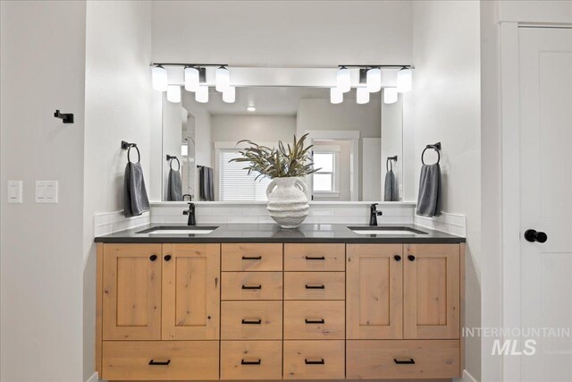 full bathroom with a sink and double vanity