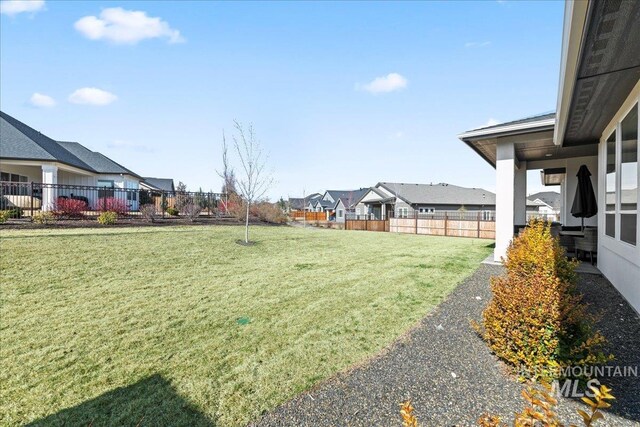 view of yard featuring fence and a residential view