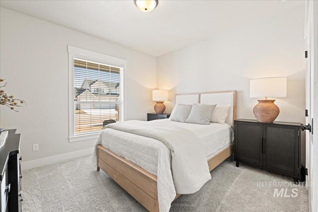 bedroom with light carpet and baseboards