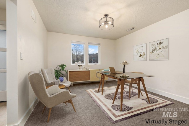 carpeted dining room with visible vents, baseboards, and a textured ceiling