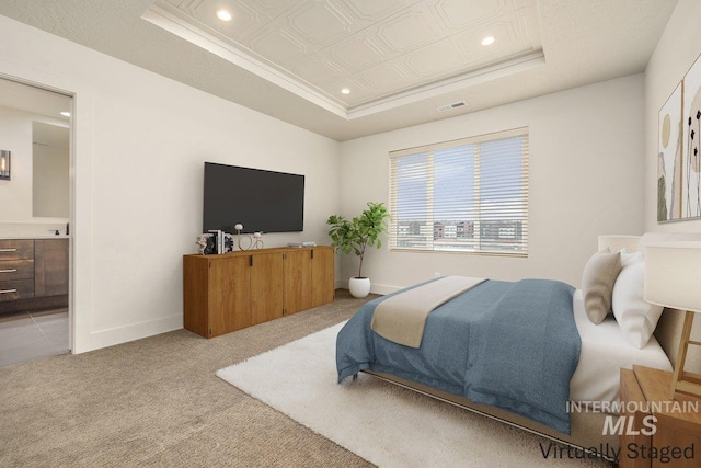 bedroom with a raised ceiling, light colored carpet, visible vents, and baseboards