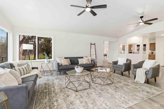living room with wood finished floors, ceiling fan, and vaulted ceiling