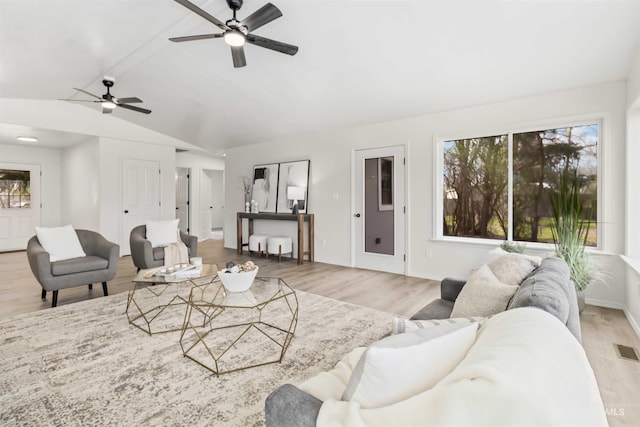 living room featuring visible vents, ceiling fan, light wood finished floors, and lofted ceiling