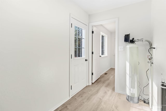 corridor featuring light wood-style floors and baseboards