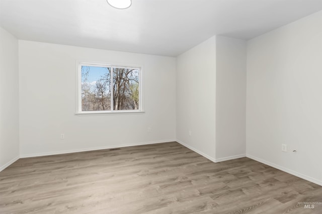 unfurnished room with light wood-style floors and baseboards