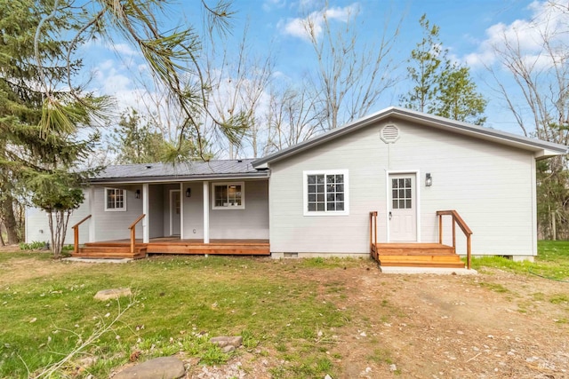 back of house featuring a porch, metal roof, crawl space, and a lawn