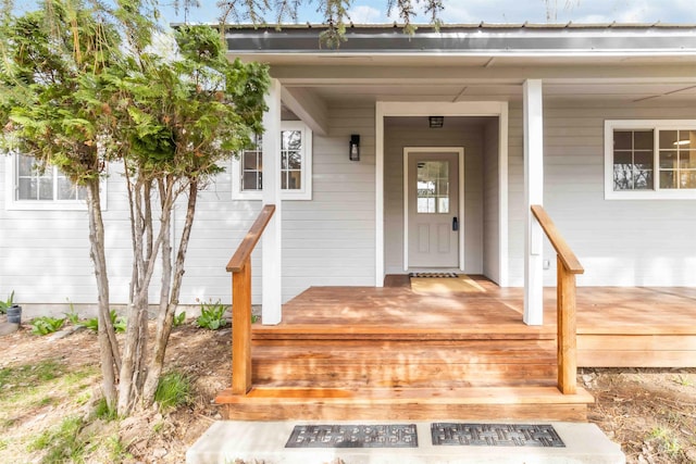 view of exterior entry featuring covered porch