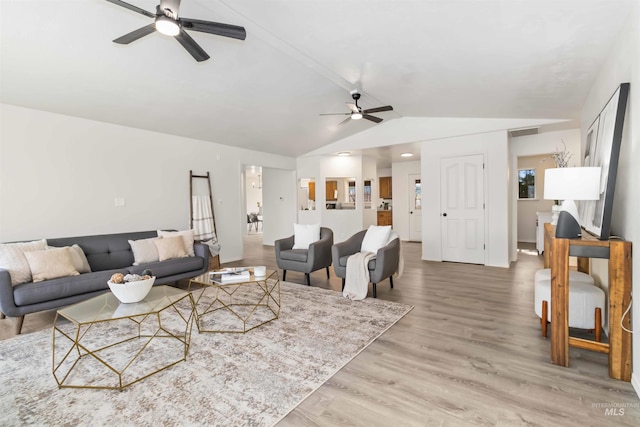 living area featuring light wood-style floors, visible vents, a ceiling fan, and lofted ceiling
