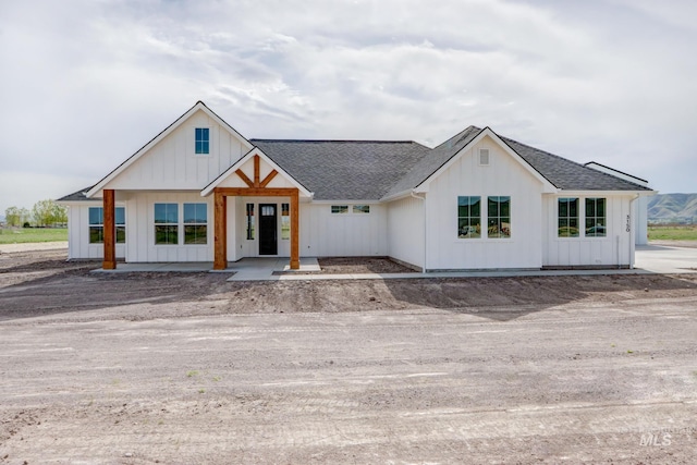 modern inspired farmhouse with a shingled roof and board and batten siding