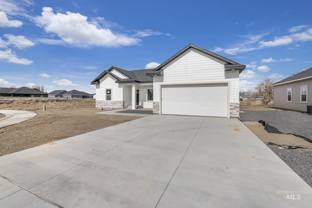 ranch-style home with stone siding, an attached garage, and concrete driveway