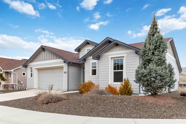 ranch-style home featuring an attached garage, board and batten siding, driveway, and roof with shingles