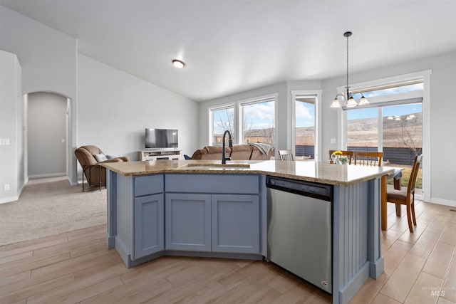 kitchen featuring light stone countertops, a sink, vaulted ceiling, stainless steel dishwasher, and open floor plan