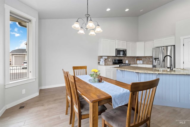 dining space with light wood finished floors, visible vents, baseboards, a chandelier, and recessed lighting