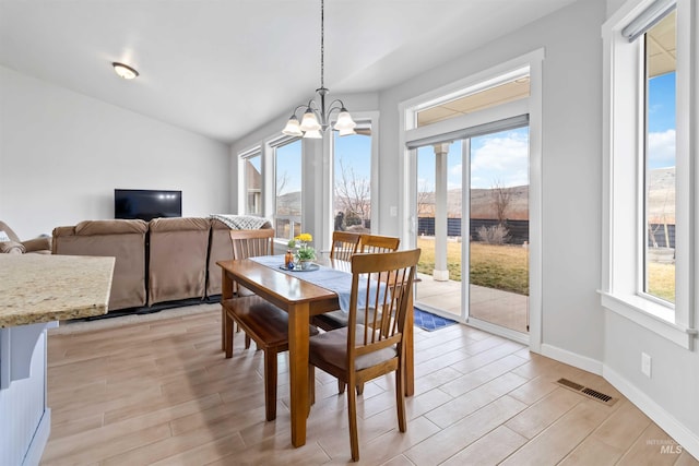 dining space featuring an inviting chandelier, a healthy amount of sunlight, visible vents, and wood tiled floor