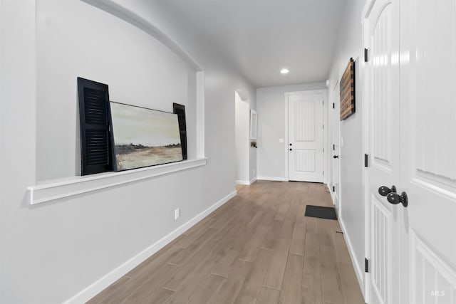 corridor featuring recessed lighting, baseboards, and wood finished floors