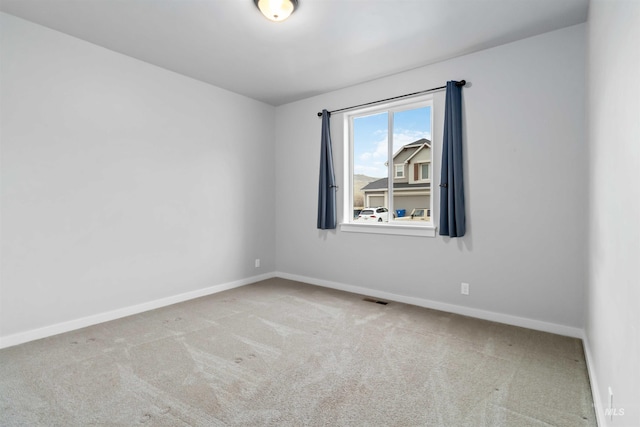 carpeted empty room with visible vents and baseboards