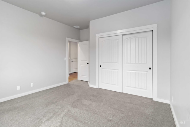 unfurnished bedroom featuring a closet, carpet flooring, and baseboards