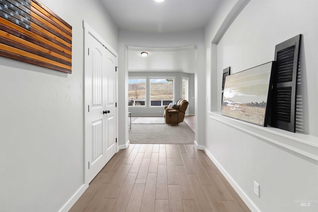 corridor featuring wood finished floors and baseboards