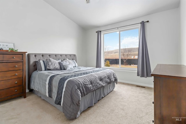 bedroom featuring light carpet, visible vents, baseboards, and vaulted ceiling