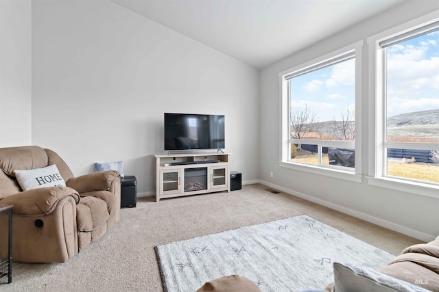 living area featuring visible vents, carpet, baseboards, and vaulted ceiling