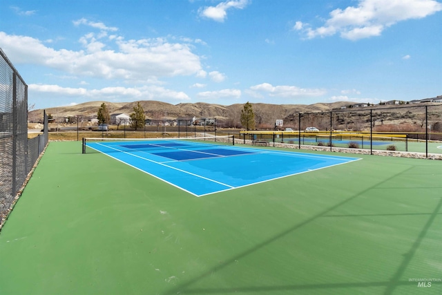 view of sport court with a mountain view and fence