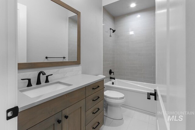 full bathroom with tiled shower / bath, vanity, toilet, and tile patterned floors