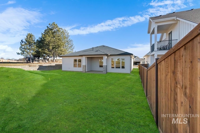 back of house featuring a lawn