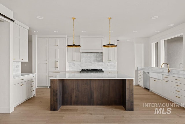 kitchen with sink, hanging light fixtures, dishwasher, a kitchen island, and stove