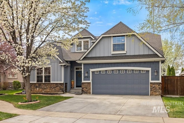 1063 Hitchcock St, Meridian, ID 83646 - craftsman-style home featuring fence, a shingled roof, concrete driveway, board and batten siding, and stone siding