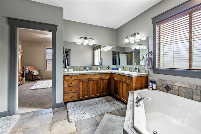 1063 Hitchcock St, Meridian, ID 83646 - full bathroom featuring double vanity, a garden tub, a healthy amount of sunlight, and a sink