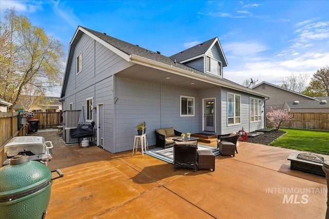 1063 Hitchcock St, Meridian, ID 83646 - back of house featuring a fenced backyard, an outdoor living space with a fire pit, and a patio