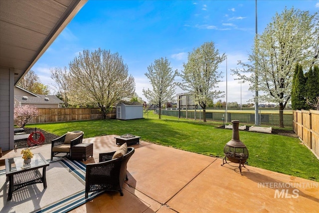 1063 Hitchcock St, Meridian, ID 83646 - view of patio / terrace featuring a fenced backyard, an outbuilding, a storage shed, and an outdoor living space with a fire pit