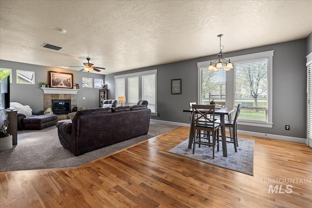 1063 Hitchcock St, Meridian, ID 83646 - living room featuring baseboards, a textured ceiling, visible vents, and a fireplace