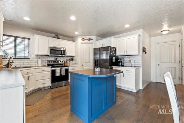 kitchen with white cabinetry, sink, stainless steel appliances, and a center island